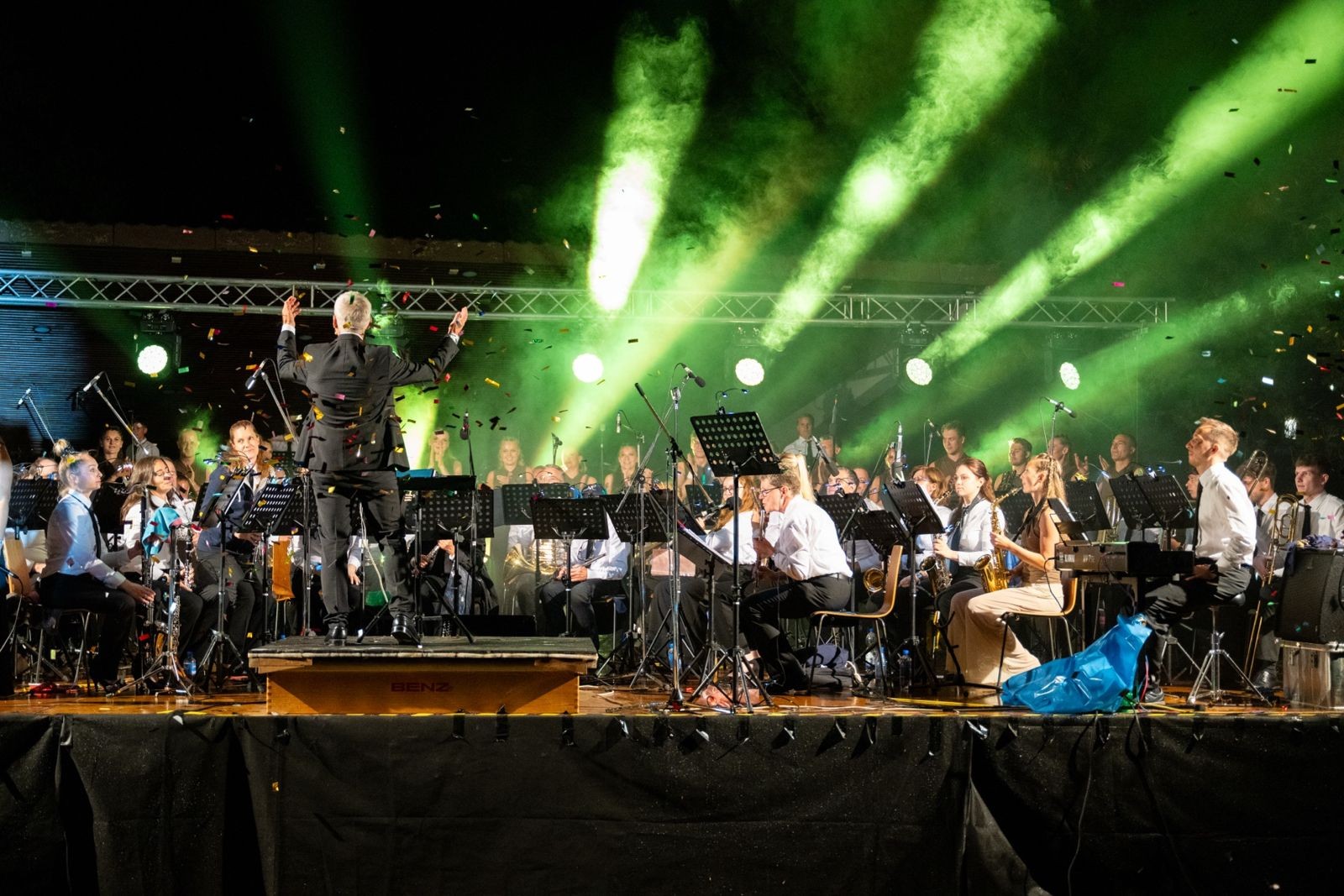 Musikverein Ludwigshafen mit Dirigent auf der Bühne unter grünen Scheinwerfern